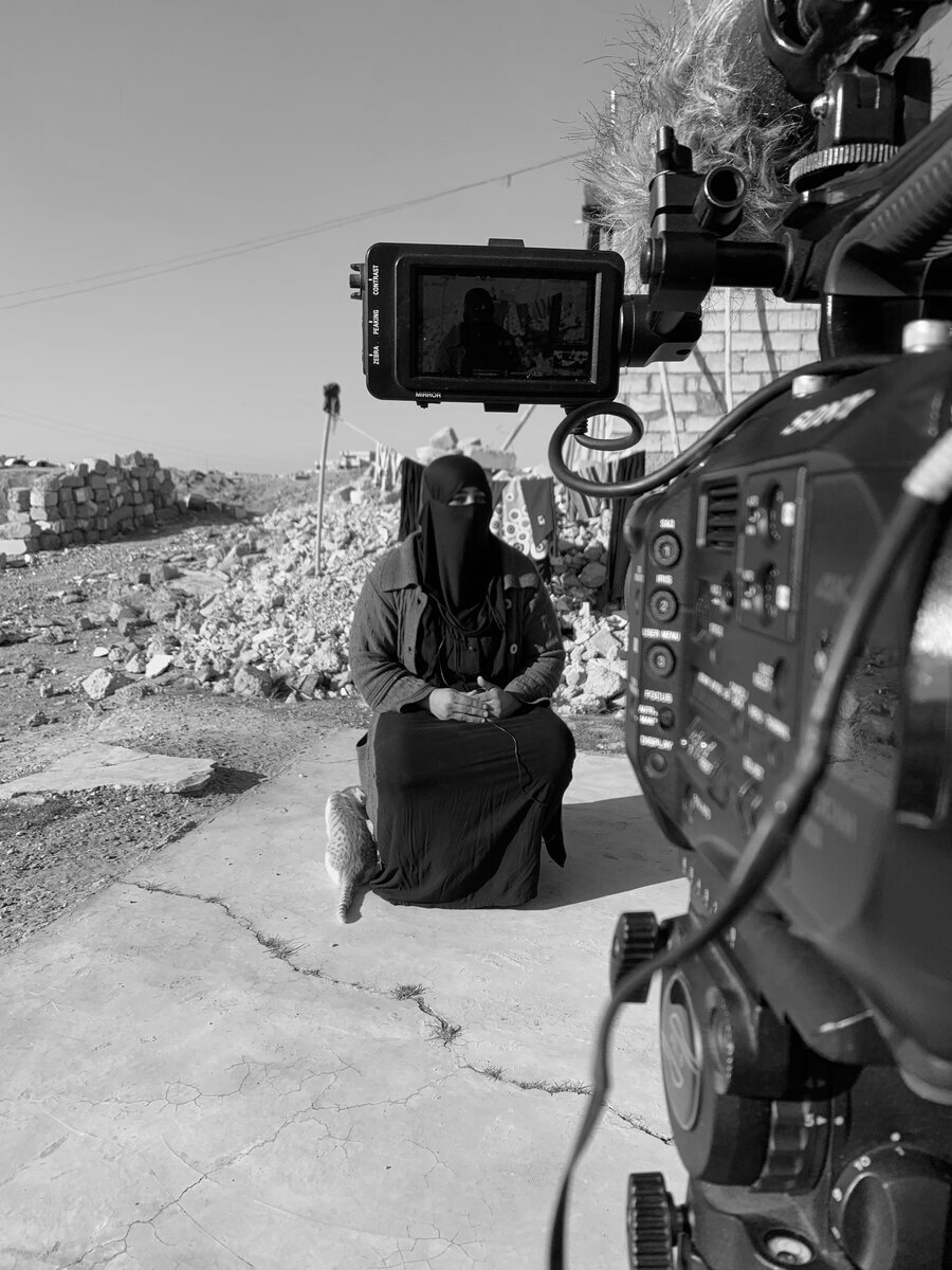 Filming a documentary subject amid rubble